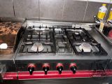 a stove top with four burners on it in a kitchen