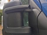 an image of a side view mirror of a blue van