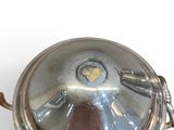 a silver plate with a lid on a white surface