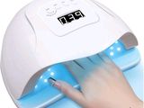 the nail dryer is being used on a woman ' s nails