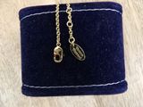 a blue velvet purse with two charms hanging from it