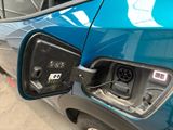 a blue car that has an electric charger attached to it