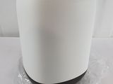 a white container with a black lid on a white table