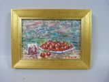 une photo d'un tableau représentant des cerises, dans un cadre doré