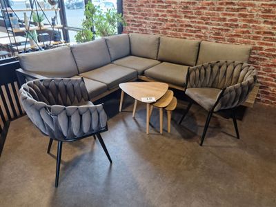 un canapé et deux fauteuils dans une pièce avec un mur en briques