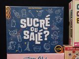 a box of sucre ou sale next to a box of toys
