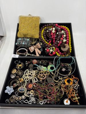 une boîte noire remplie de bijoux variés posée sur une surface blanche
