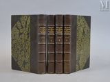 trois livres sont empilés sur une surface blanche