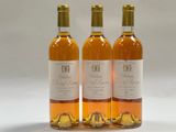 trois bouteilles de vin posées les unes à côté des autres sur une surface blanche