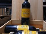 Plusieurs bouteilles de vin sont posées dans une caisse en bois sur une table