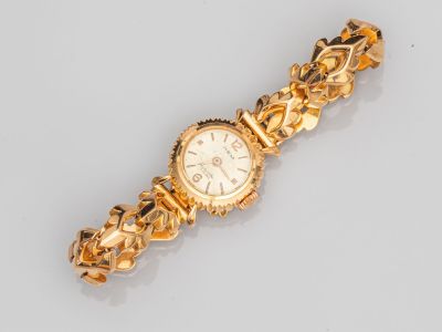 gros plan d'une montre-bracelet en or sur une surface blanche