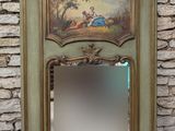 un miroir orné d'une peinture, placé devant un mur de pierre