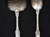 two spoons and a spoon rest on a black surface