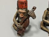two figurines of monkeys sitting next to each other