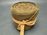 une image représentant un rouleau de tissu marron auquel est noué un ruban marron