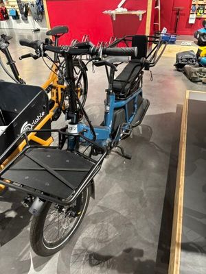 un vélo bleu et jaune avec un coffre à l'arrière