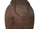un grand vase marron muni d'une anse en corde