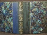 un vieux livre à la couverture bleue posé sur une table
