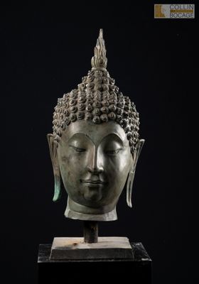 une tête de Bouddha en bronze sur fond noir