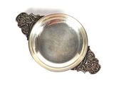 une assiette en argent avec une poignée, posée sur un fond blanc
