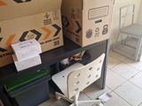 a desk with a chair and boxes on it