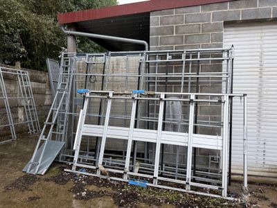 un tas d'échelles métalliques devant un immeuble