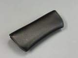 étui en cuir noir pour téléphone portable posé sur une surface blanche