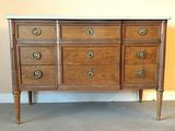 une commode ancienne avec un plateau en marbre et des poignées en laiton