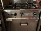 une cuisinière en acier inoxydable dans une cuisine au sol carrelé