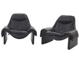une paire de fauteuils de salon en cuir noir aux pieds courbés
