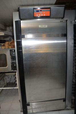 a stainless steel refrigerator in a kitchen with a microwave in the background