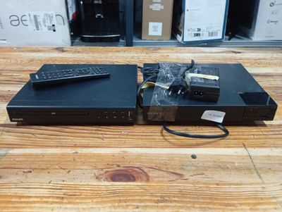 two remotes sitting on top of a wooden table