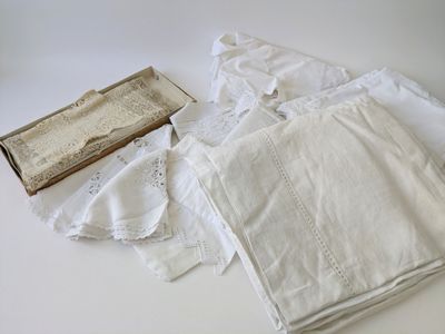 several pieces of white linen are laid out on a table