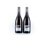 two bottles of wine sitting next to each other on a white surface