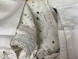 a pile of old white cloths on a bed