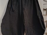 a black pants hanging on a wall next to a shelf