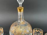 four glasses and a decanter sitting on a table