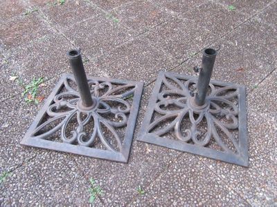 paire de porte-parapluies anciens en fonte, posés au sol