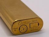 an image of a gold lighter sitting on top of a white surface