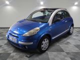 La petite voiture bleue est garée dans le garage, sur le sol à carreaux.