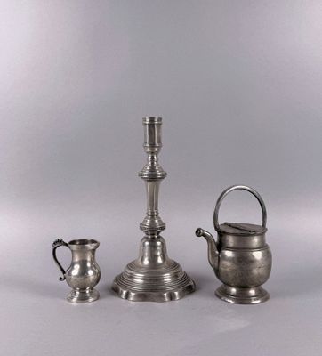 three pieces of silverware including a teapot, cup and saucer
