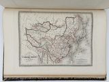 an old map of china in a book on a table