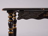 a close up of a wooden table with black and gold decorations on it