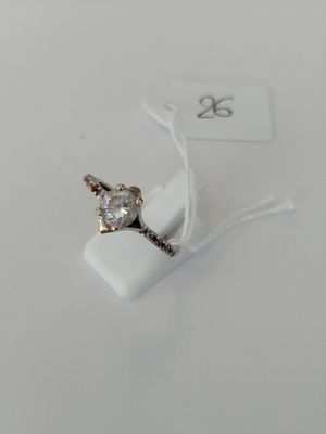 a ring with a diamond on it sitting on a white surface