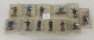 de nombreuses figurines de soldats disposées dans des boîtes en plastique sur une table
