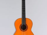 une guitare orange accrochée à un mur sur fond blanc