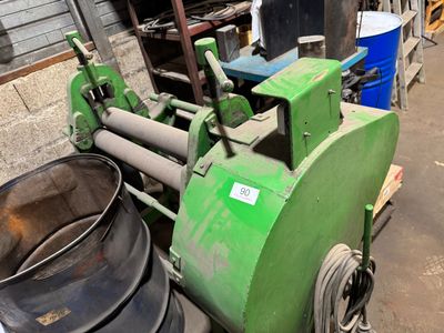 une machine verte posée à côté d'une poubelle