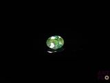 a close up of a green and white diamond on a black surface
