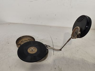 un disque noir et doré posé sur une surface blanche