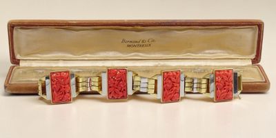 une photo d'un bracelet manchette rouge et or dans un écrin
